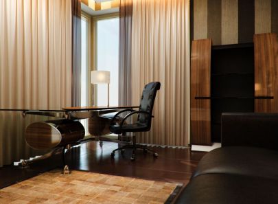 Дизайн рабочего кабинета с фигурным столом в коричневых тонах