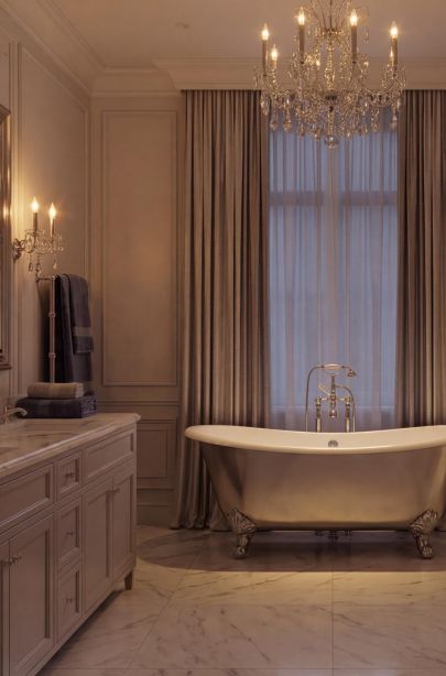 Ванная комната с классической ванной на ножках, мраморным полом и текстильными шторами