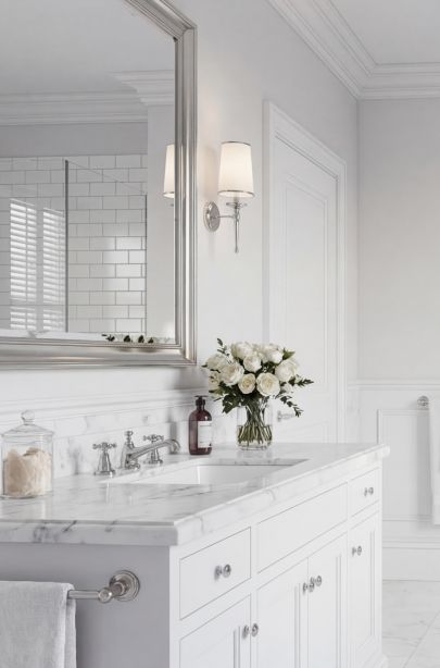 Зона умывальника с мраморной столешницей, зеркалом и классическими светильниками