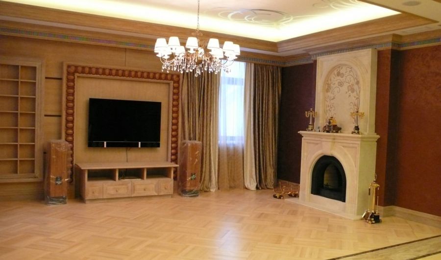 Портал камина из лепнины и отделка деревом в гостиной