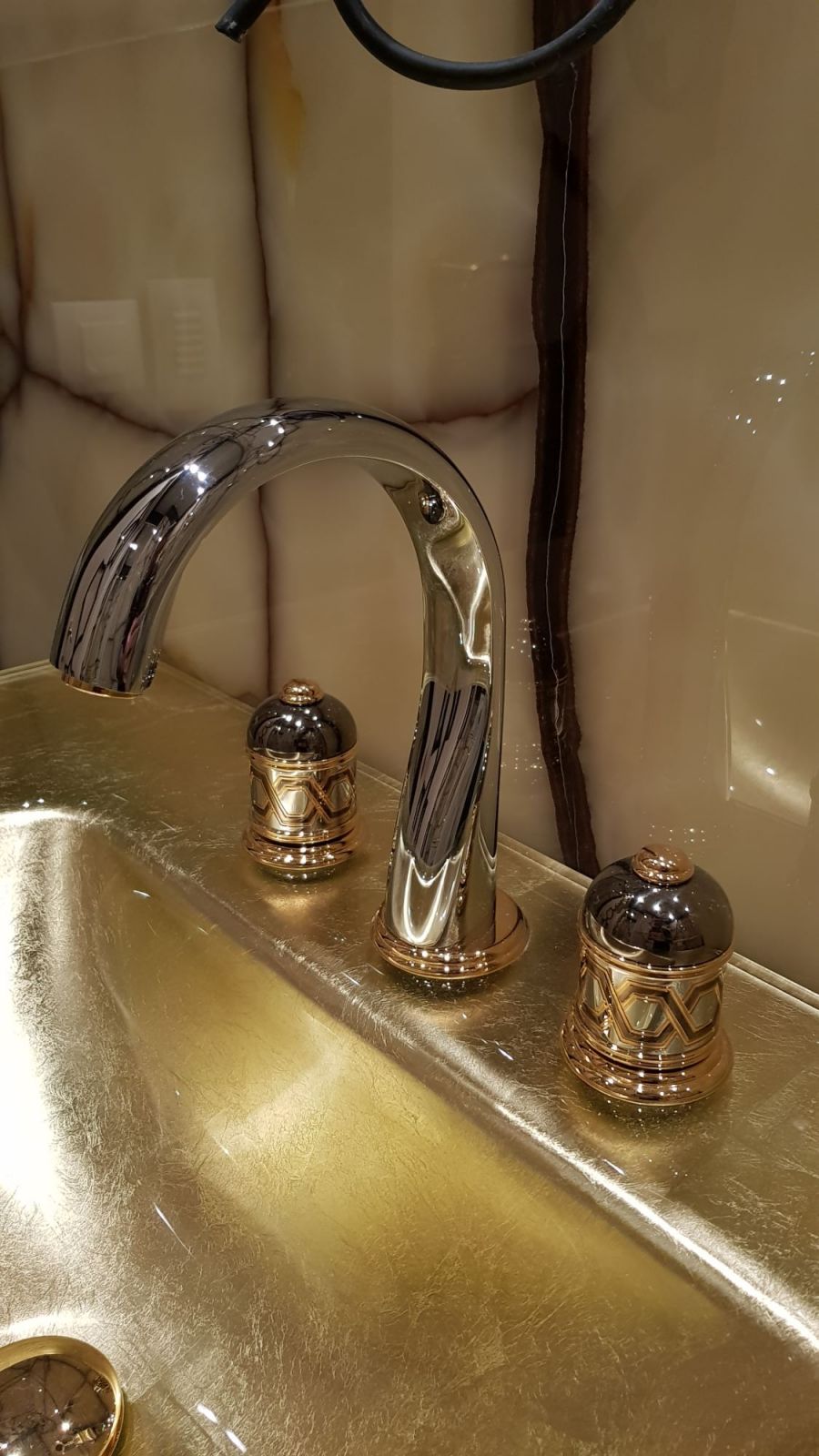 Хромированный кран-смеситель с декорированными вентилями в дизайне санузла